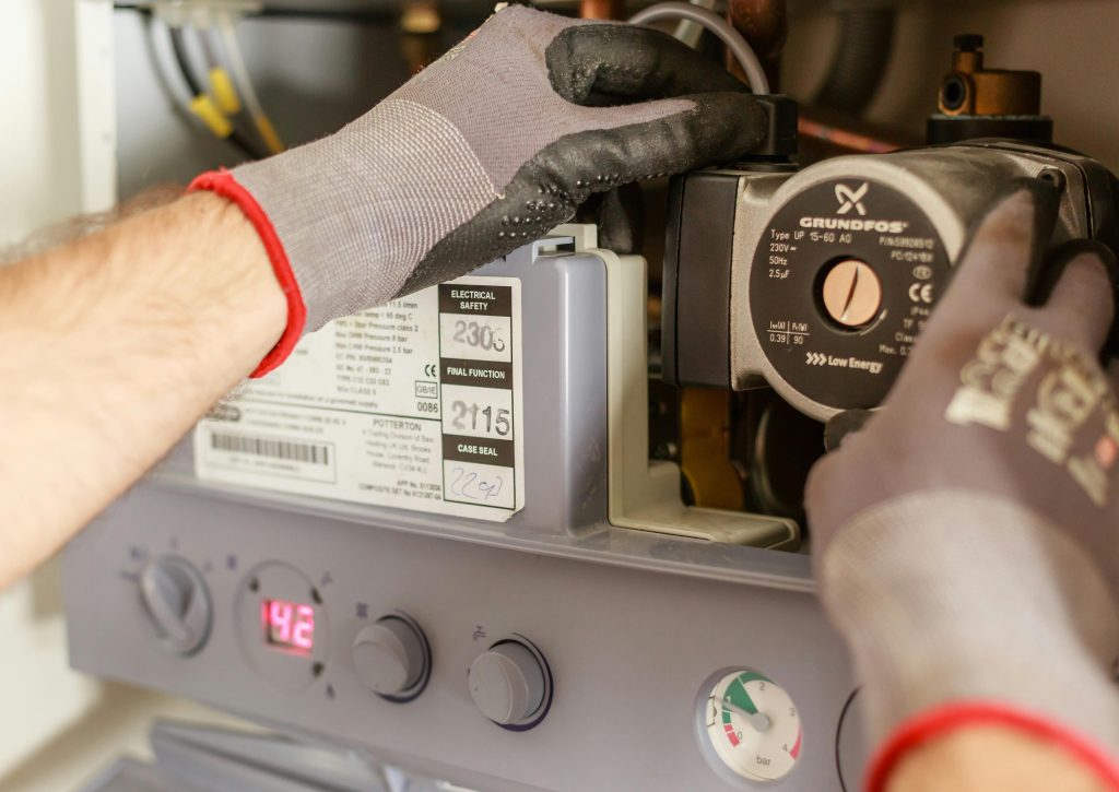 Hands inside open gas boiler